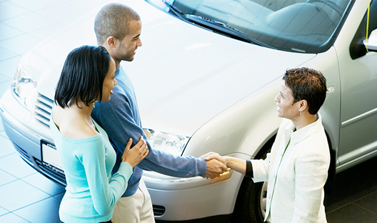 Young couple agreeing to purchase a new car