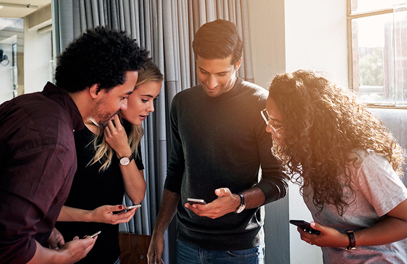 Group of youngsters looking at social media on mobile phone