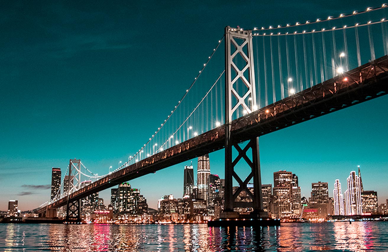 San Francisco bridge with city in backdrop at night
