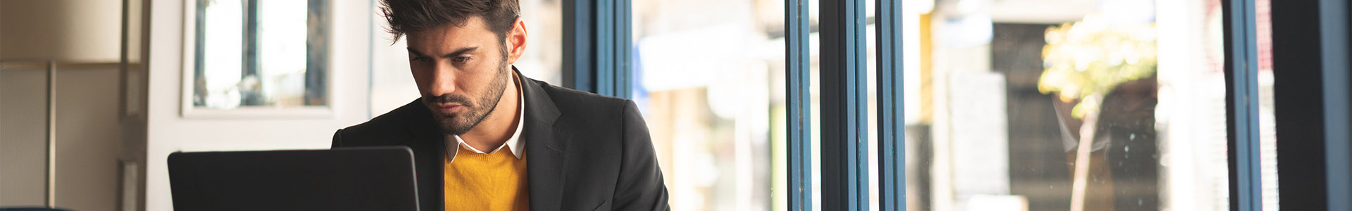 Male professional preparing LinkedIn profile sitting in cafe