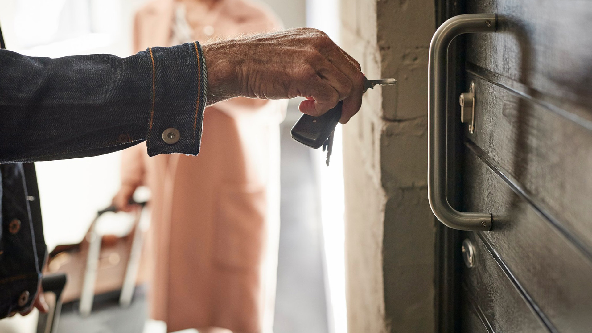 Man putting key into a door