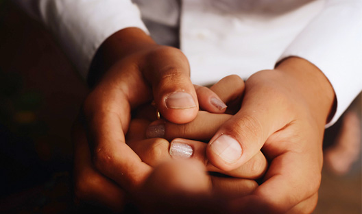 Close-up of parent holding child's hand