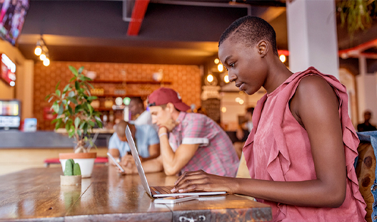 Young female working on her LinkedIn profile sitting in a coffee shop