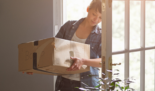 Woman bringing a box into a room