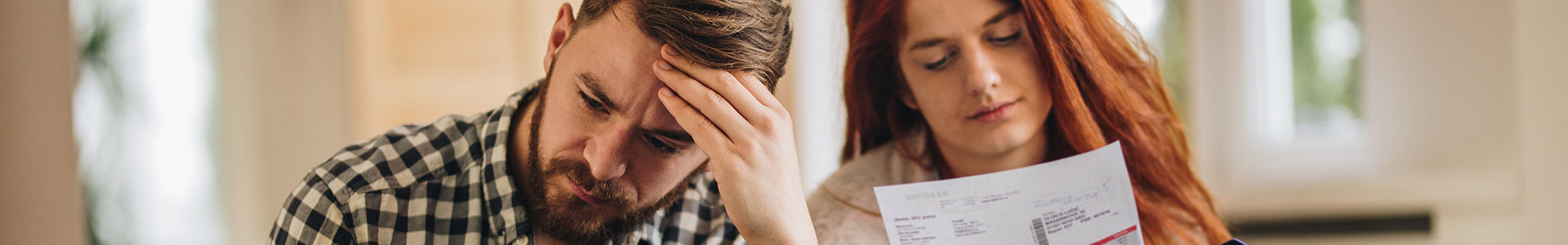 Worried couple feeling frustrated while have to pay their bills over Internet.