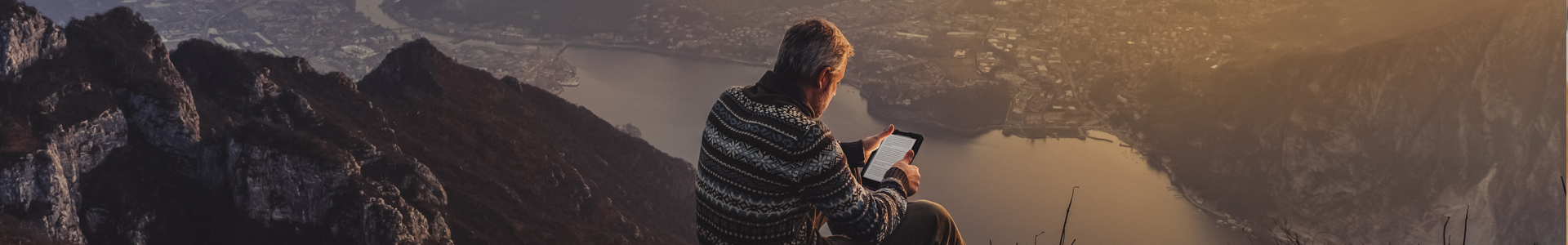 Man reading tablet on a mountain
