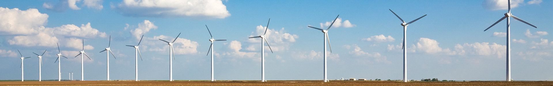 Row of wind turbines against a blue sky
