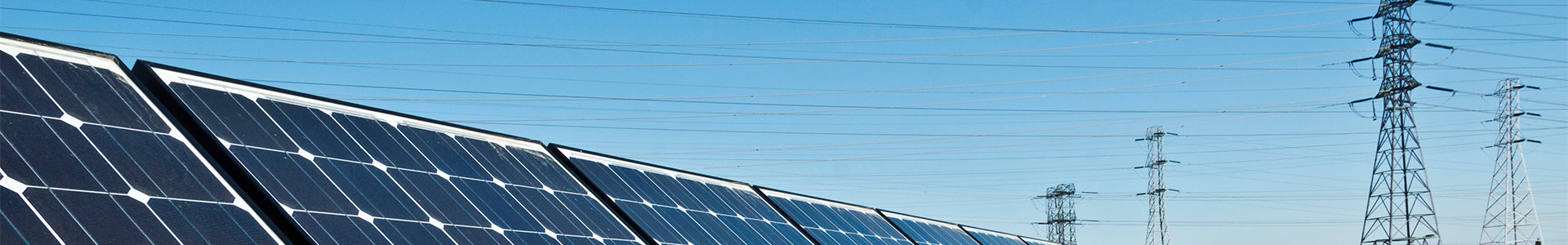 Solar panels with transmission lines in background