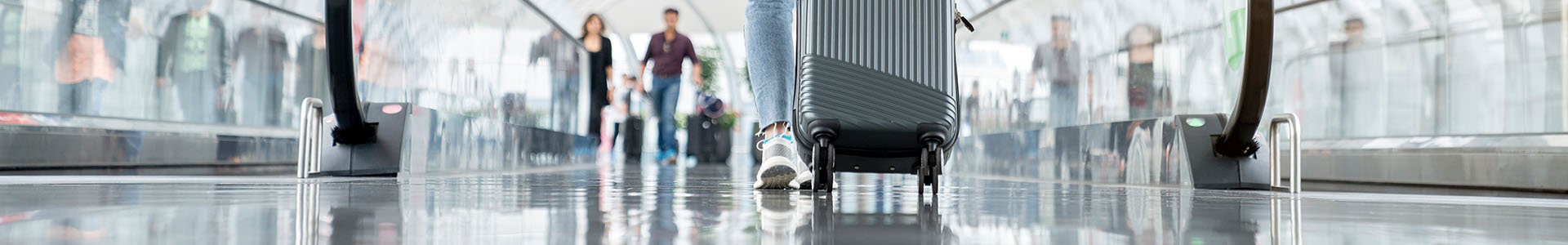 Woman rolling bag through an airport