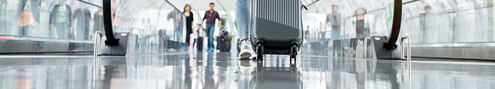 Woman rolling bag through an airport