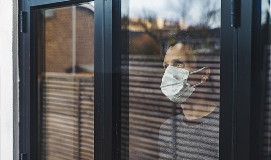 masked man looking out the window