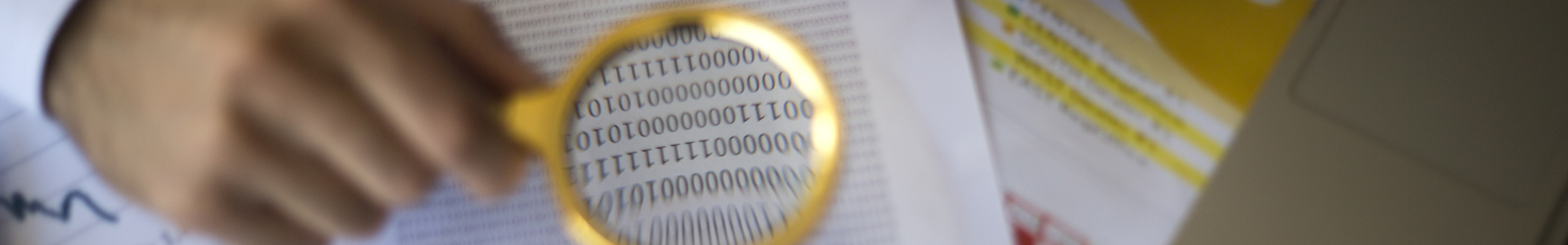 Auditor using a magnifying glass to review financial statements