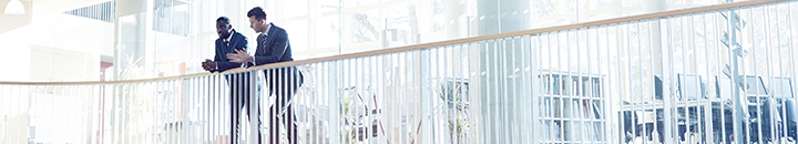 Business men looking over a balcony