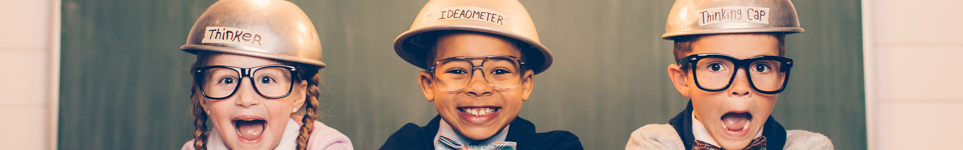 Three young kids wearing thinking caps