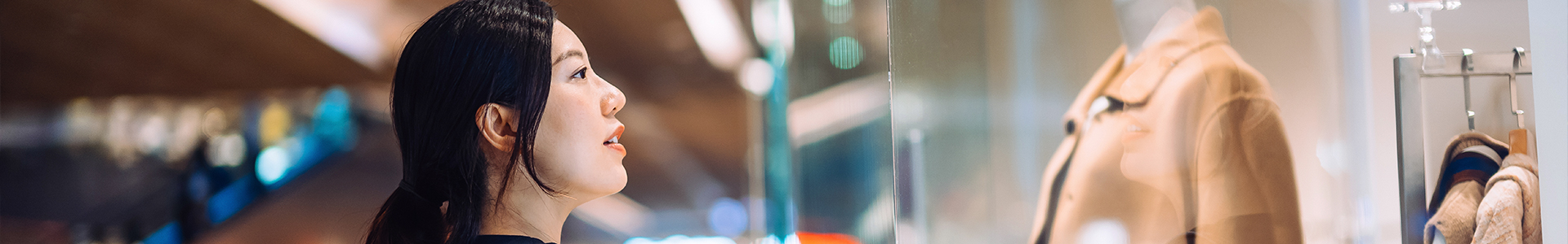 Woman looking at window display while in shopping mall