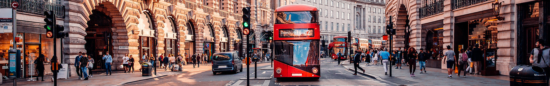 Busy London street with red bus heading towards the camera