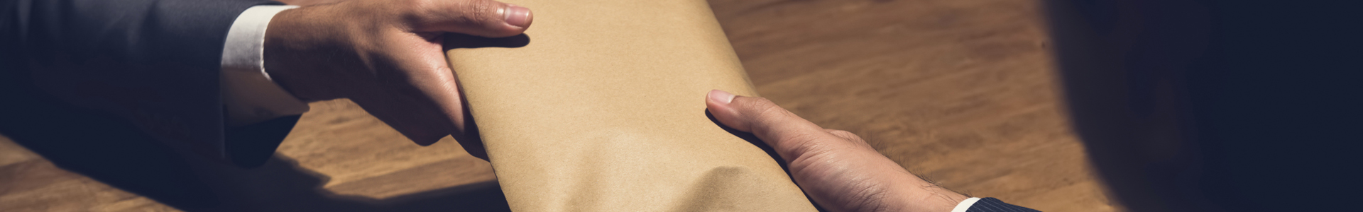 Bribe being paid in a brown envelope
