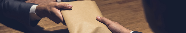 Bribe being paid in a brown envelope