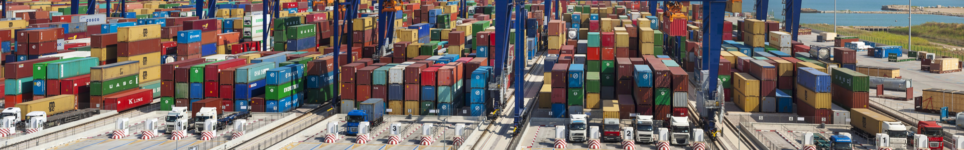 Shipping containers being loaded onto trucks