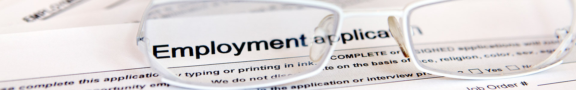 Employment application form with glasses sitting on top