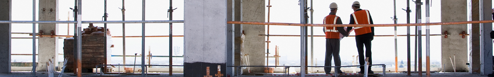 2 construction workers standing in a high rise building