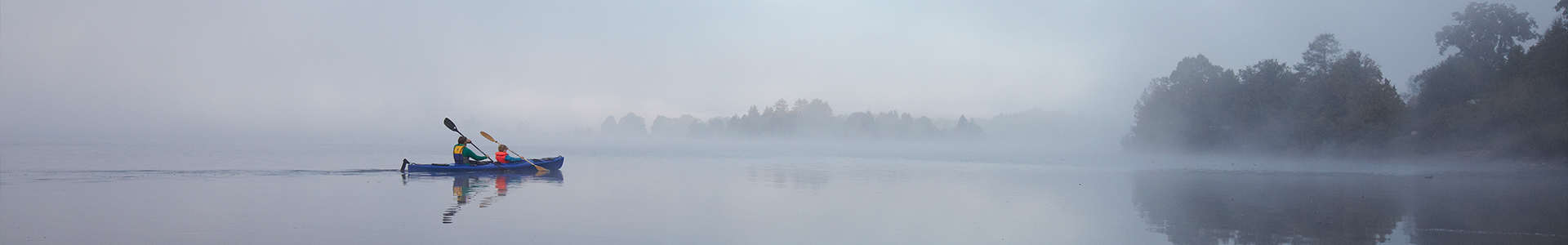 2 people on a kayak in a foggy lake