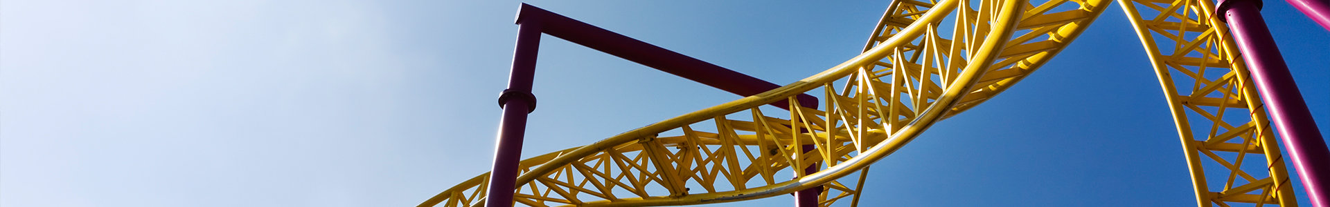 A yellow roller coaster in a theme park
