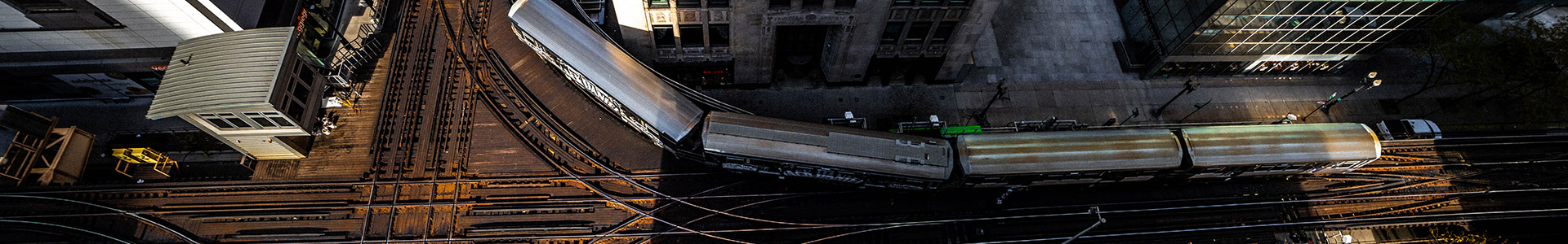Train turning around a sharp corner in the track which is working around a building