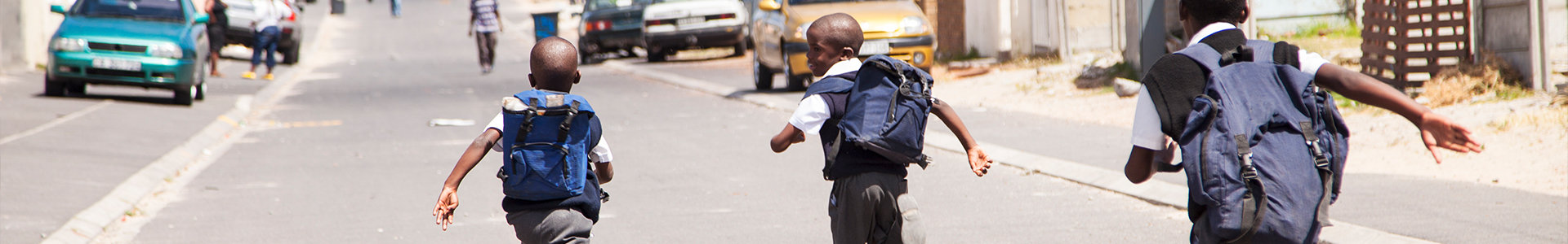 Three young boys running down the street, Cape Town, South Africa