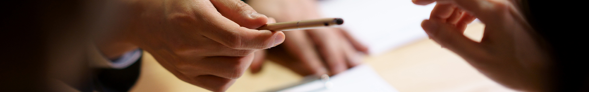 Solicitor handing pen to client to sign power of attorney document