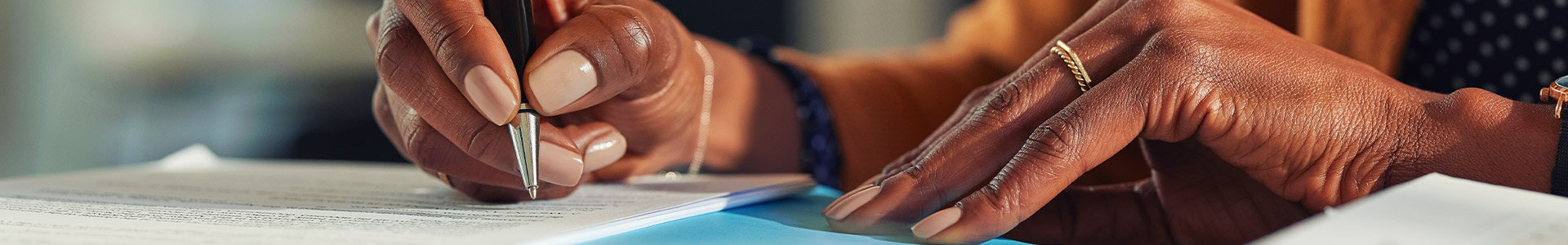 Female writing notes about live insurance on to a paper pad