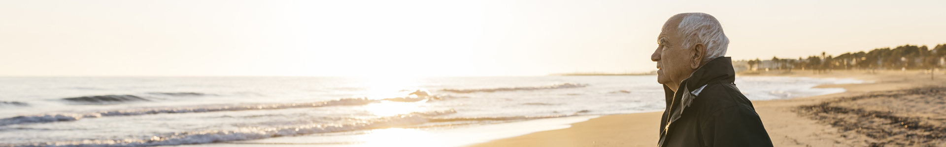 Elderly man staring out at sea