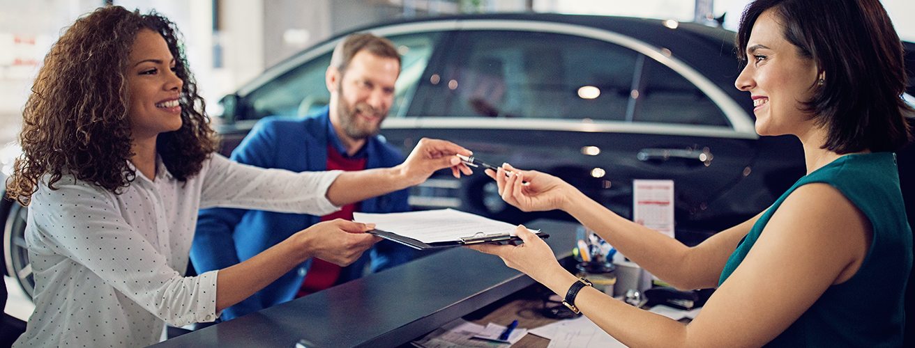 Couple at a car dealership doing paperwork