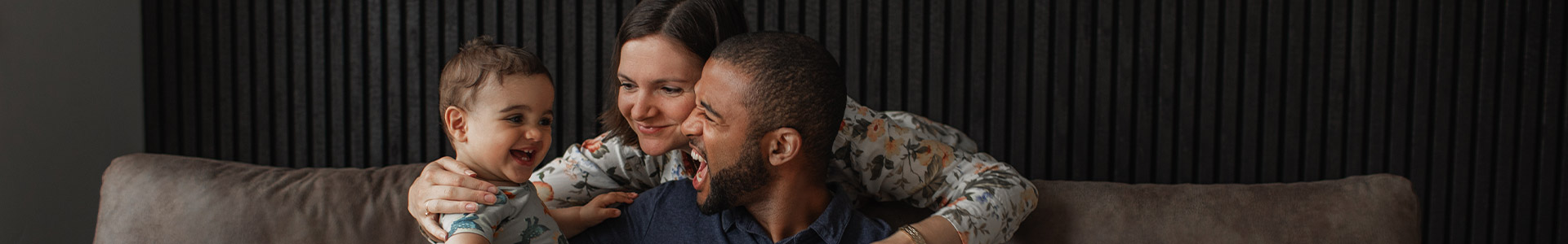 Young father having fun at home with his wife and toddler son
