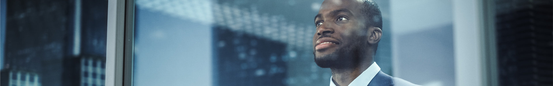 Business man looking out over city skyline at night