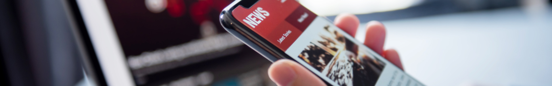 Hand scrolling through news on a cellphone