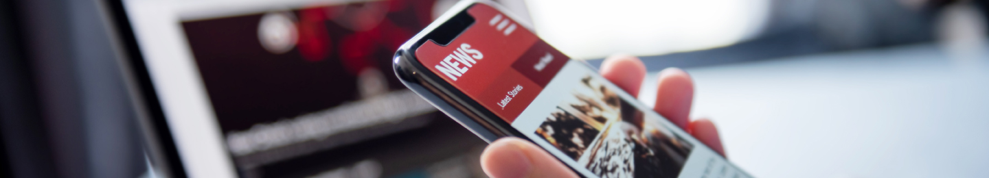 Hand scrolling through news on a cellphone
