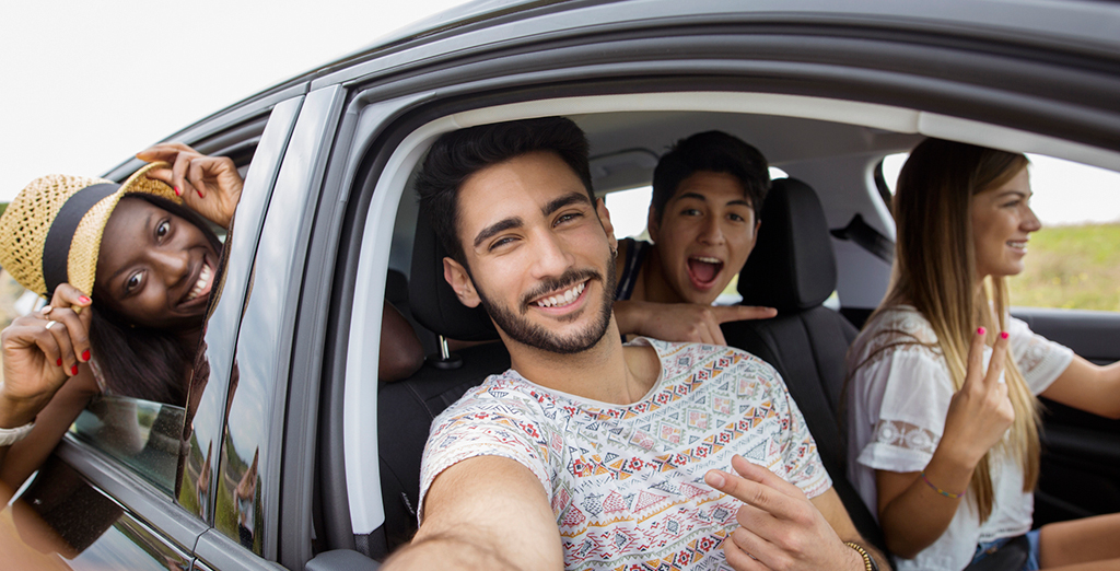 group of young professionals taking a selfie from inside a new car