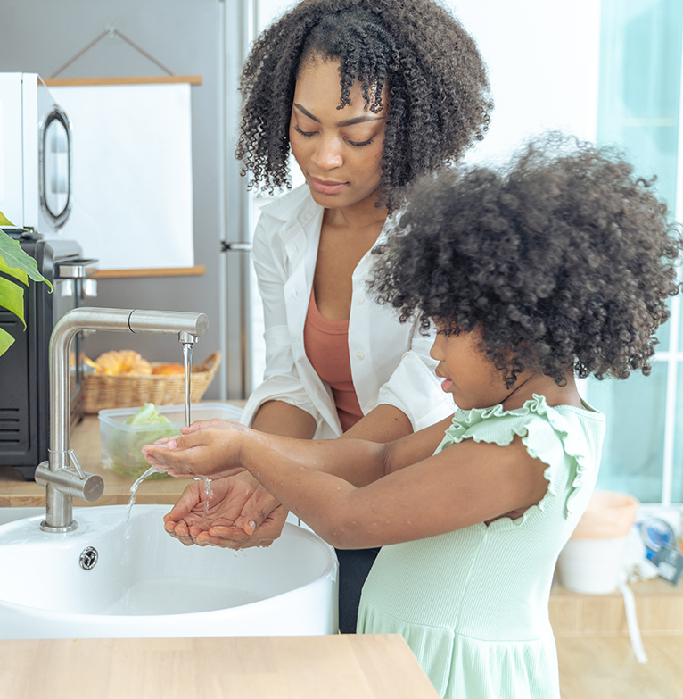 A mother and daughter washing their hands