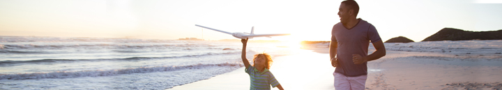 Travel | Father and son play on a beach with an aeroplane