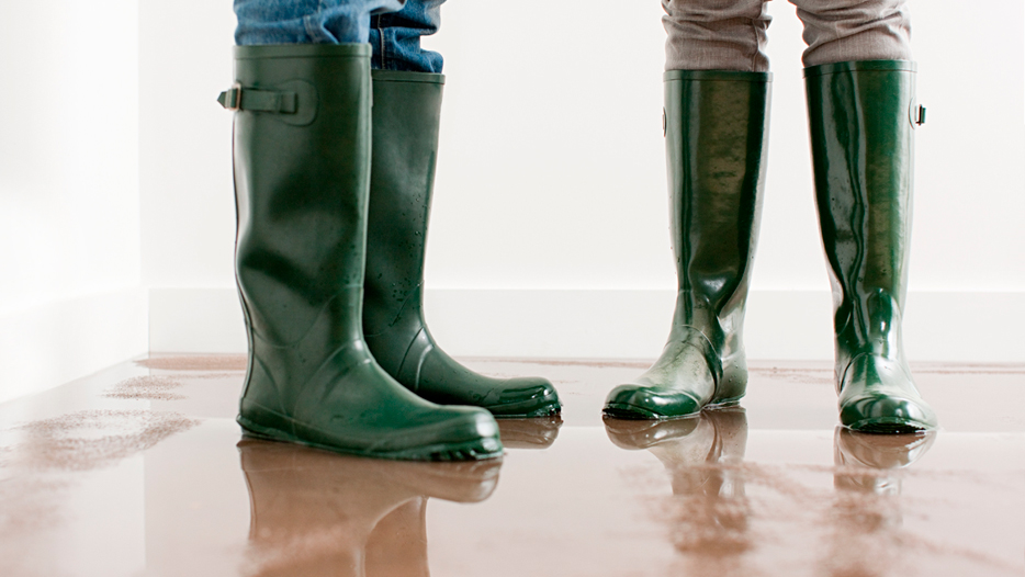 AON | couple wearing rain boots in a flooded room