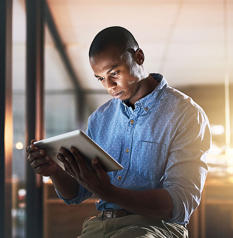 Business man sitting on his laptop working on his digital investment platform on a step outdoors with a bicycle next to him 