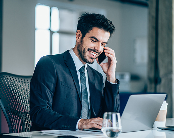 Young businessman at his desk, talking on phone