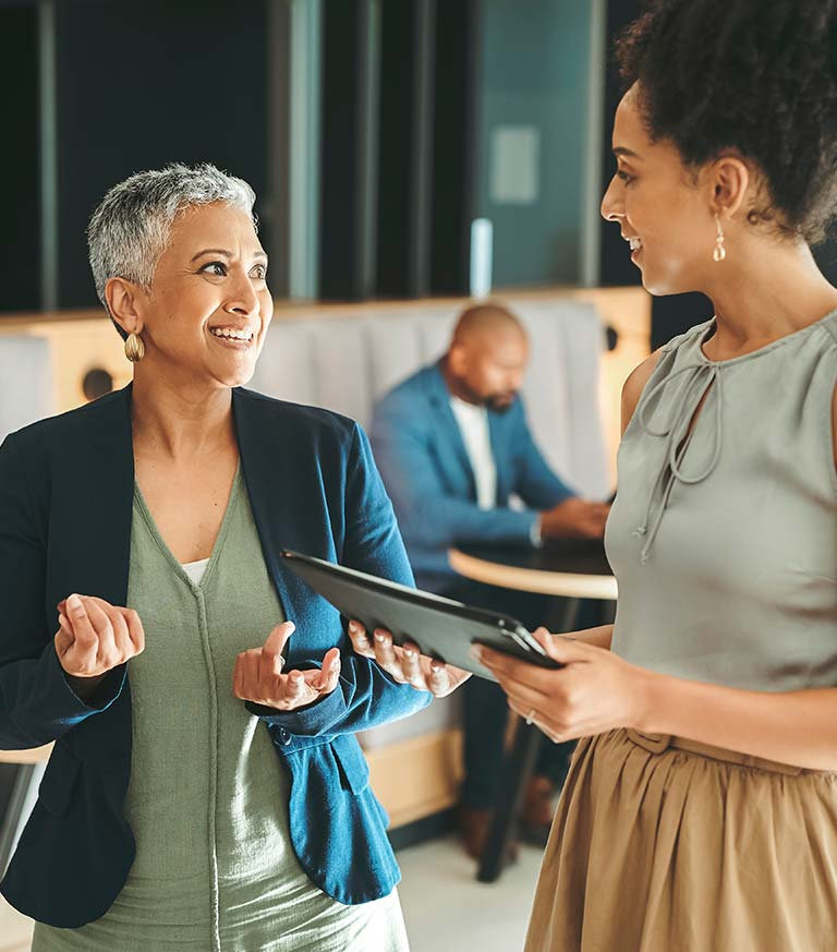 two ladies chatting in a corporate building