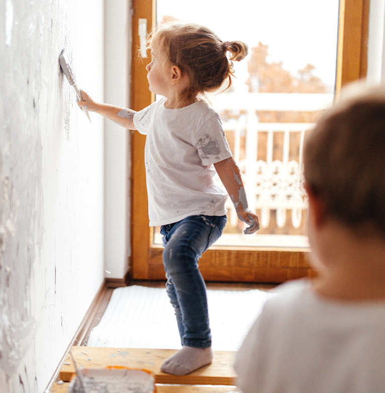 Young girl painting wall