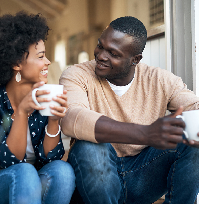 A couple in south Africa shares a coffee moment on their doorstep chatting.