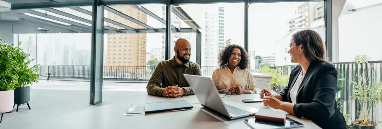A couple with their advisor in a glass office