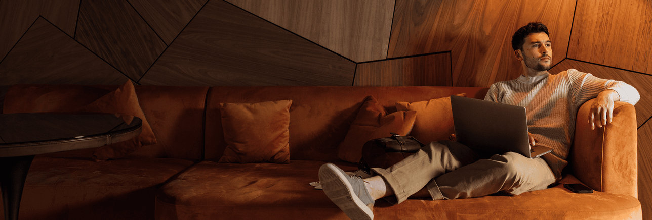 Young man lounging on couch in contemplative mood