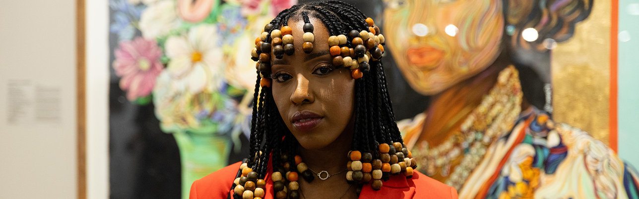 Artist poses in front of her work