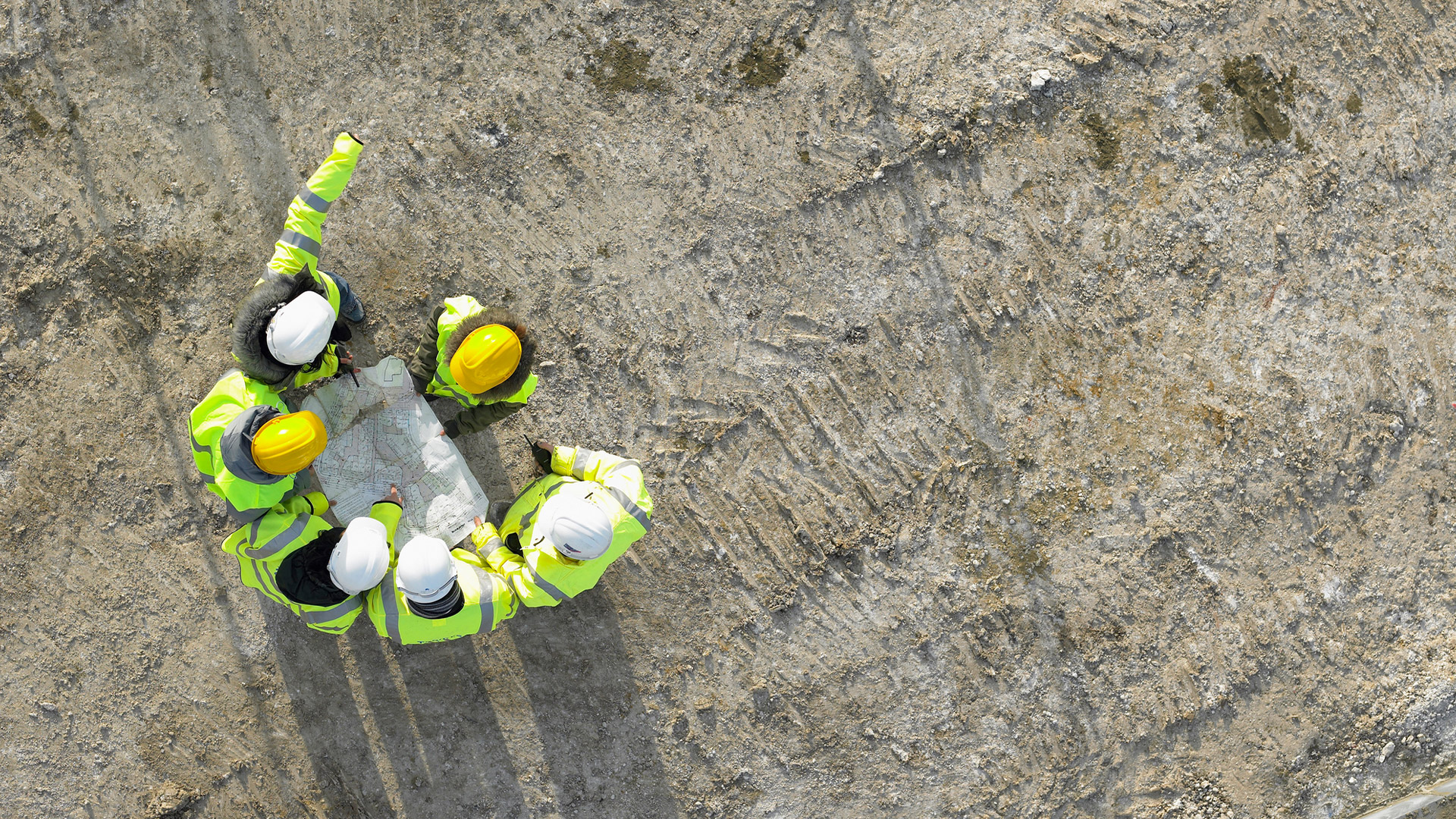 Builders in hard hats surveying the site